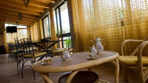 A room with a round table set for tea, wicker chairs, and a checkered curtain. - Agriturismo Tempa del Niglio (Ascea)