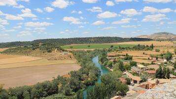Paisaje rural con un río, campos y edificios dispersos.