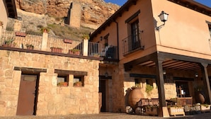 A stone building with a balcony and a large barrel. - Posada de Zorita de los Canes (Zorita de los Canes)