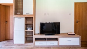 Une chambre moderne dotée d’un meuble de rangement en bois, d’un téléviseur à écran plat et d’étagères intégrées.