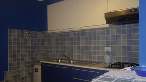 A kitchen with blue cabinets, a stainless steel sink, and a gas stove. - B&B Ciliegio Felice (Argenta)