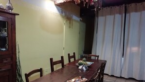 A dining area with a wooden table, chairs, and a cabinet. - B&B Ciliegio Felice (Argenta)