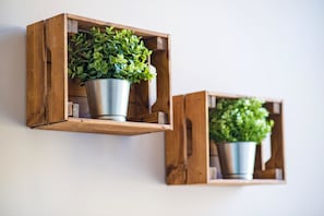 Two wooden wall-mounted planters with green foliage.