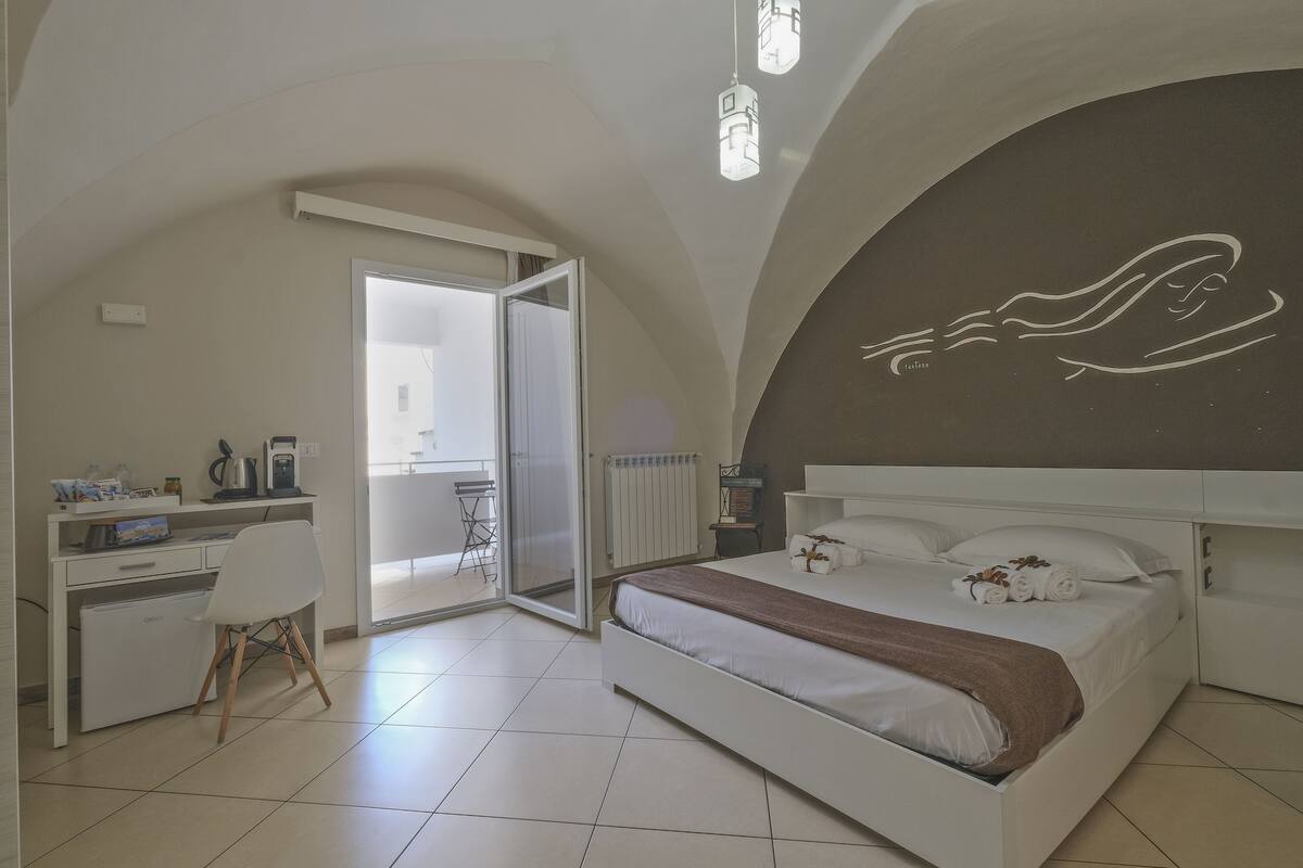 Un dormitorio con cama, escritorio y silla.
