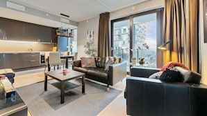 Uma sala de estar moderna com sofá, mesa de centro e área de jantar.
