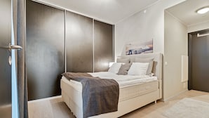 Quarto moderno com cama, guarda-roupa grande e um quadro na parede.
