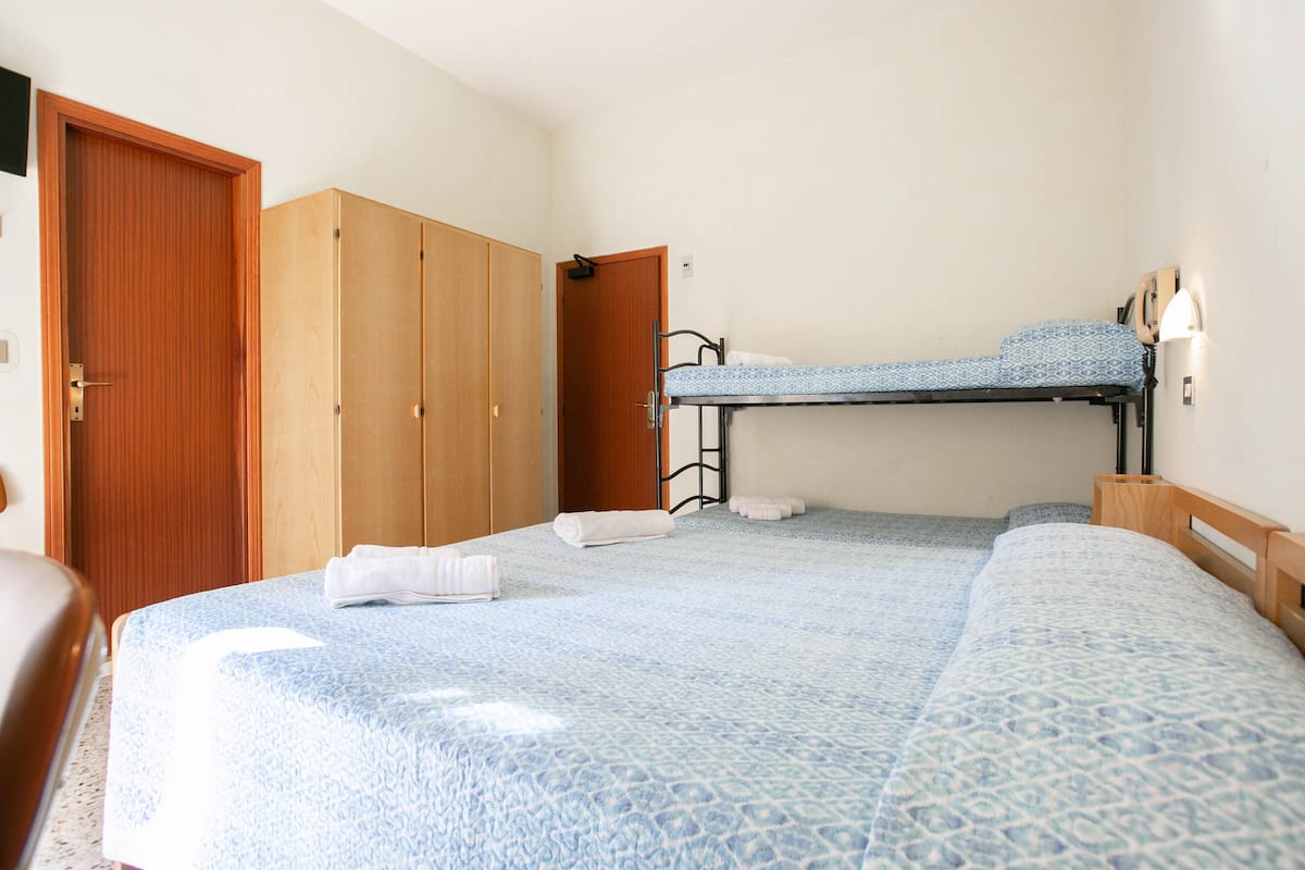 Habitación cuádruple | Caja de seguridad en la habitación, escritorio y cuna de viaje