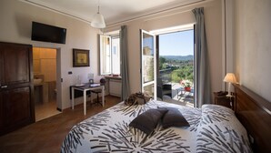 Une chambre avec un grand lit, un bureau et une vue sur l’extérieur.