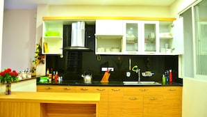 Una cocina moderna con armarios de madera, encimera negra y estufa empotrada.