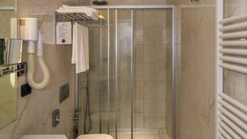 Un baño moderno con ducha acristalada, lavamanos e inodoro.