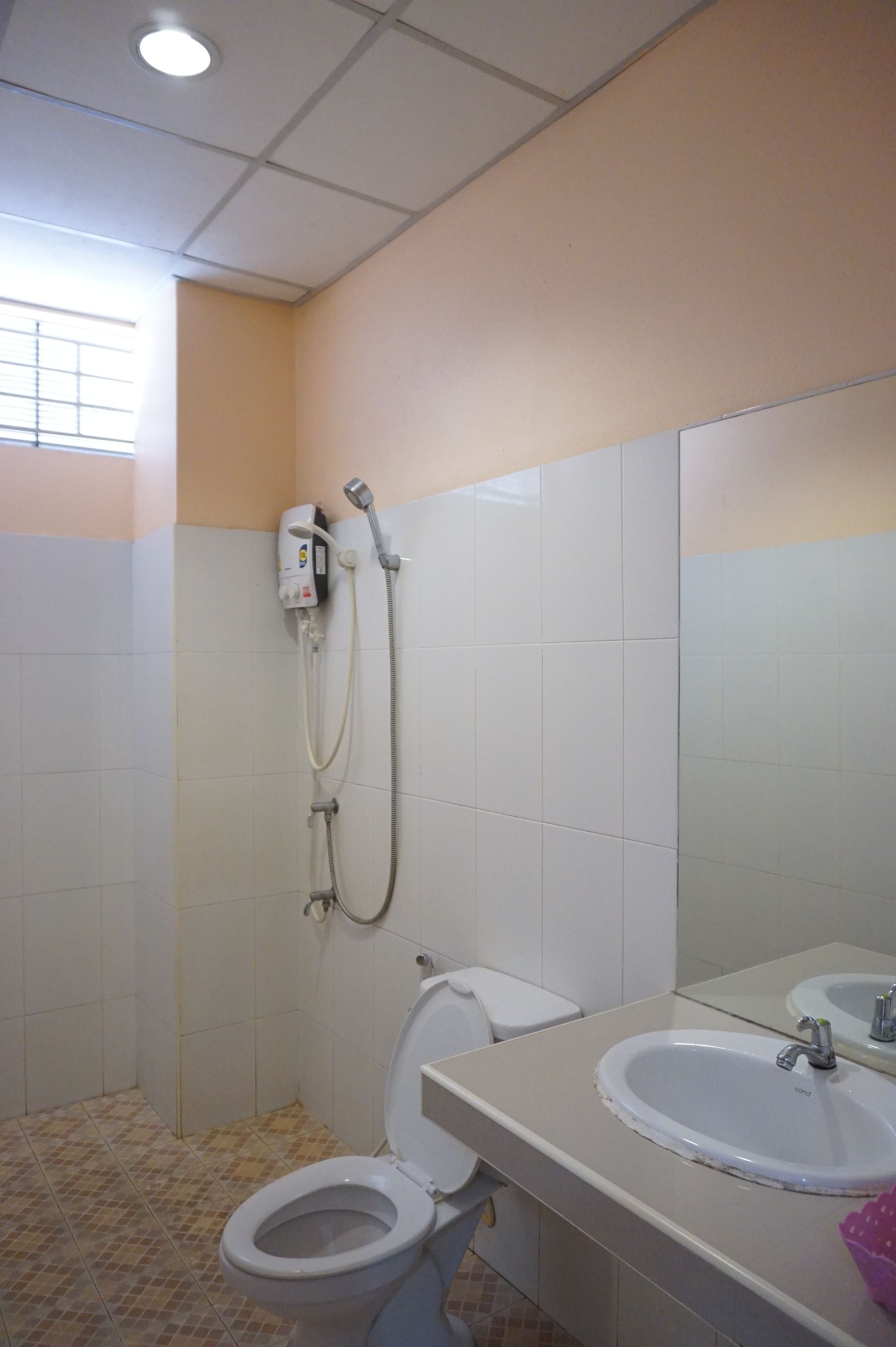 A bathroom with a toilet, sink, and shower.