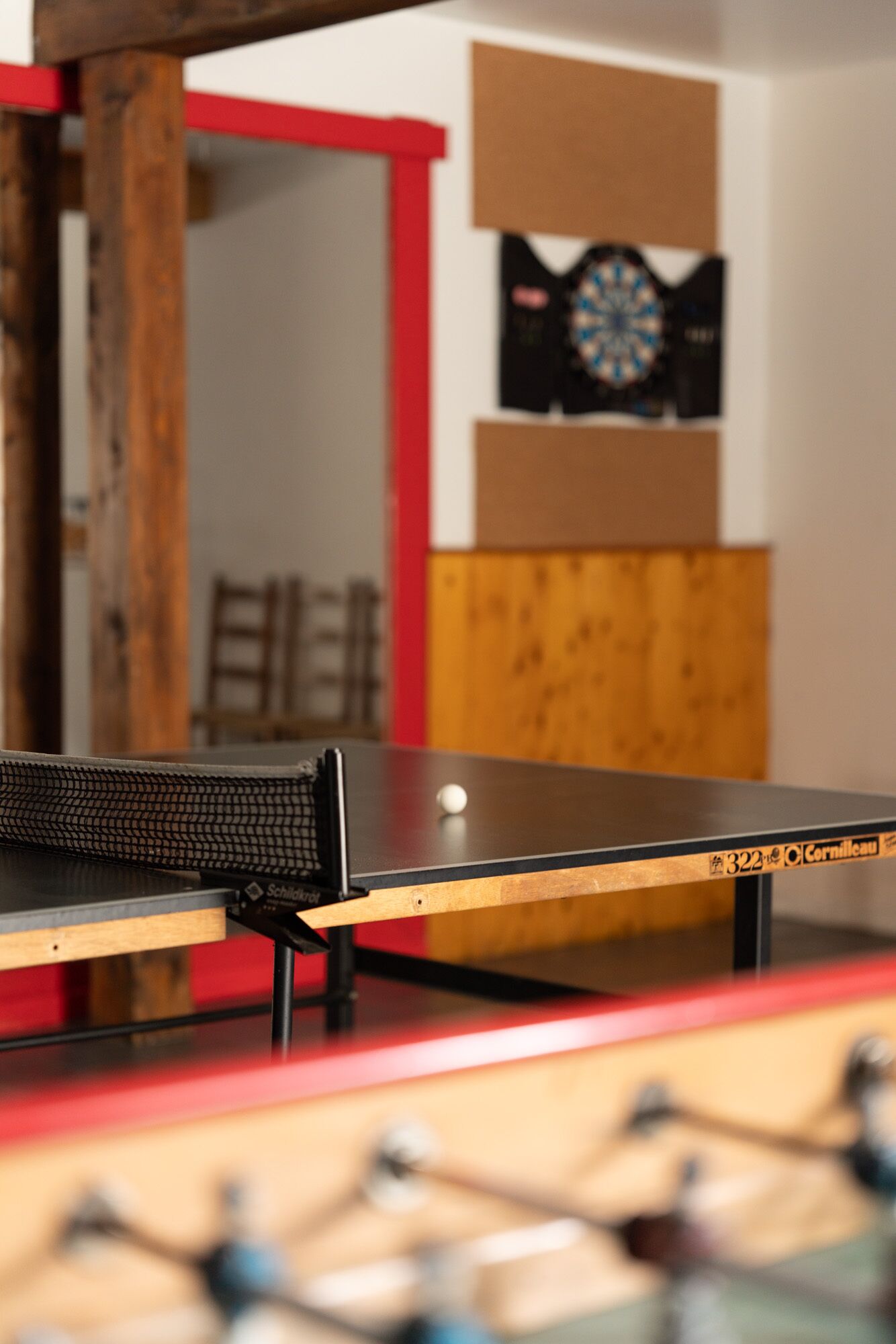 Un tavolo da ping pong con un bersaglio da freccette e un'altra freccetta sullo sfondo.