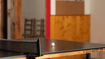 Un tavolo da ping pong con un bersaglio da freccette e un'altra freccetta sullo sfondo.