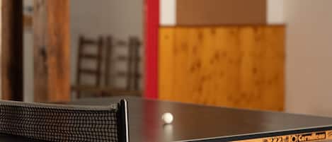 Un tavolo da ping pong con un bersaglio da freccette e un'altra freccetta sullo sfondo.