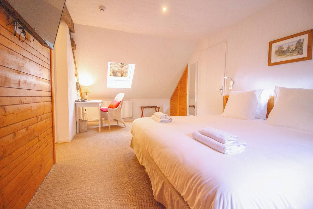 Une chambre à coucher avec un lit, un bureau et une chaise.