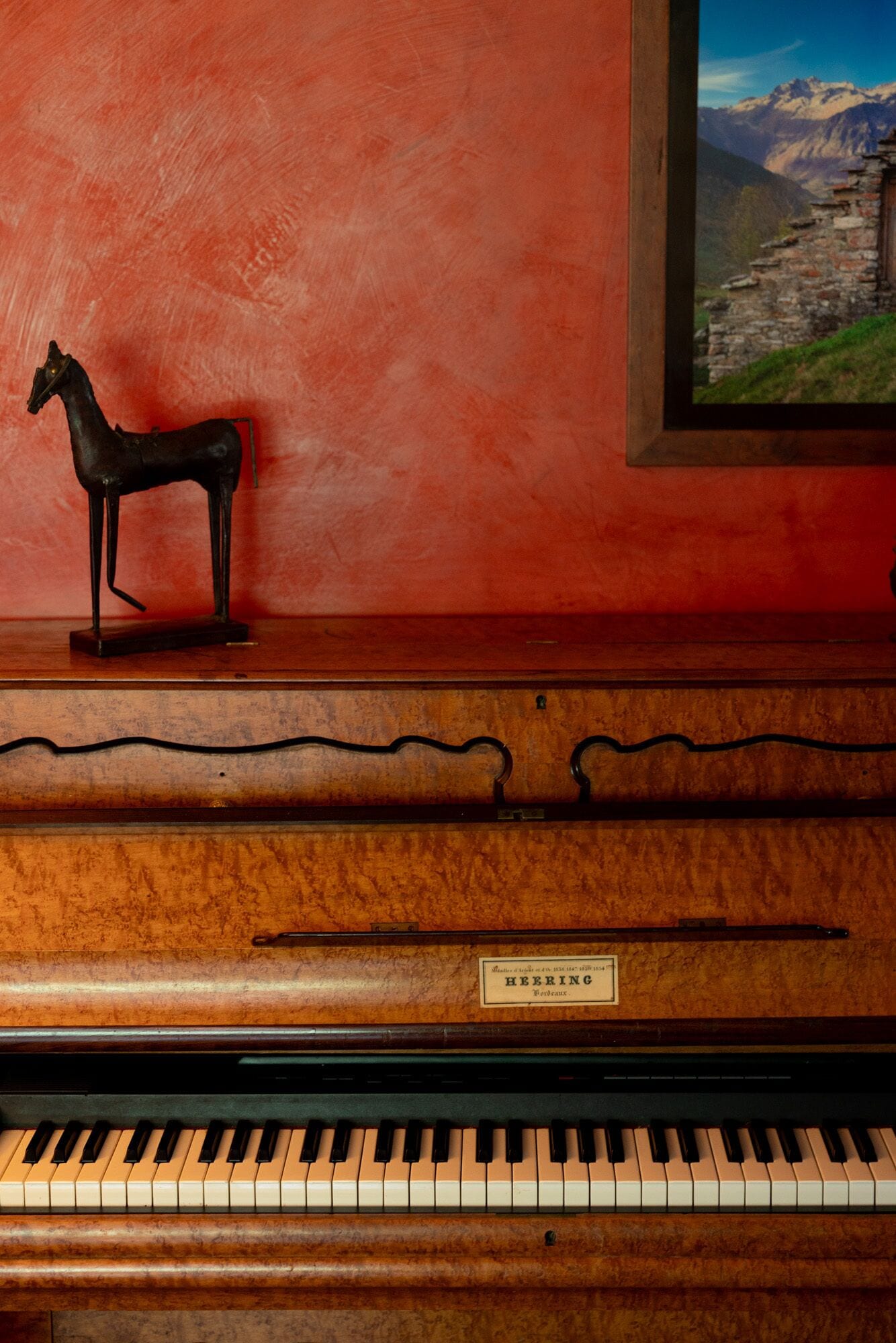 Un piano con acabado de madera y una etiqueta que indica que es de la marca Heering.