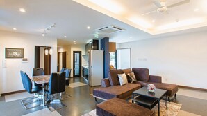 Eine moderne Hotelhalle mit Essbereich, Sitzgelegenheiten und einer Küchenzeile.
