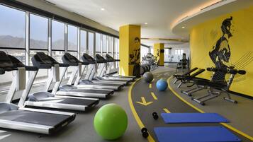 A gym with treadmills, exercise balls, and weights.