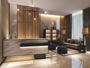 Un moderno salón con un mostrador de recepción de mármol, un panel de pared de madera y un sofá con cojines azules.