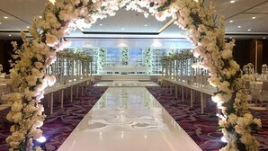 A banquet hall with a long white table, white chairs, and floral decorations. - Fraser Suites Muscat (Muscat)