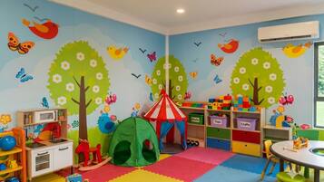 A children's playroom with a colorful play area, a tent, and storage shelves.