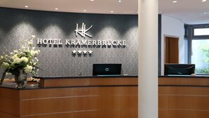 En receptionsdisk med modern design, försedd med hotellets logotyp och namn.