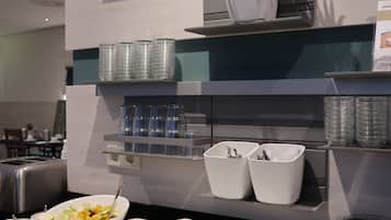 A buffet setup with various food items and condiments.