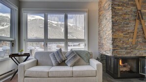 A cozy living room with a large window, a fireplace, and a sofa with decorative pillows. - Private Mountain Town home Pet Friendly with Great Views - WD12 by Redawning (Copper Mountain)