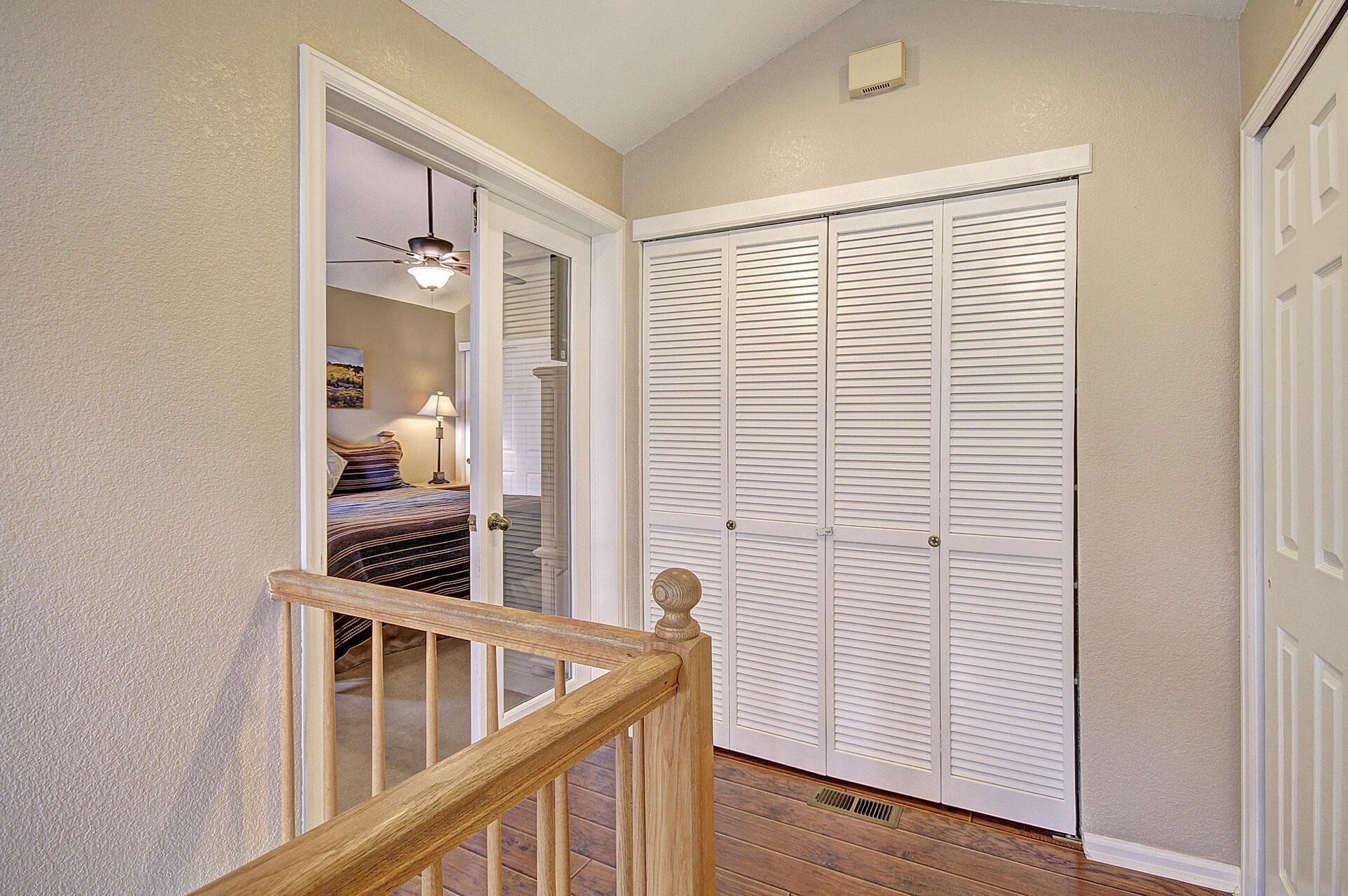 A hallway with a wooden staircase leading to a bedroom.