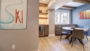 Una cocina moderna con comedor, vigas de madera y un ventanal grande.