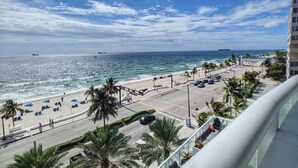 A beachside view with a road, palm trees, and a building. - 1201 W S 1 Bedroom Condo by RedAwning (Fort Lauderdale)