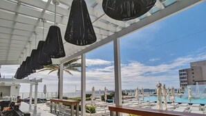 A rooftop bar with a pool view, white umbrellas, and a clear sky. - 1201 W S 1 Bedroom Condo by RedAwning (Fort Lauderdale)