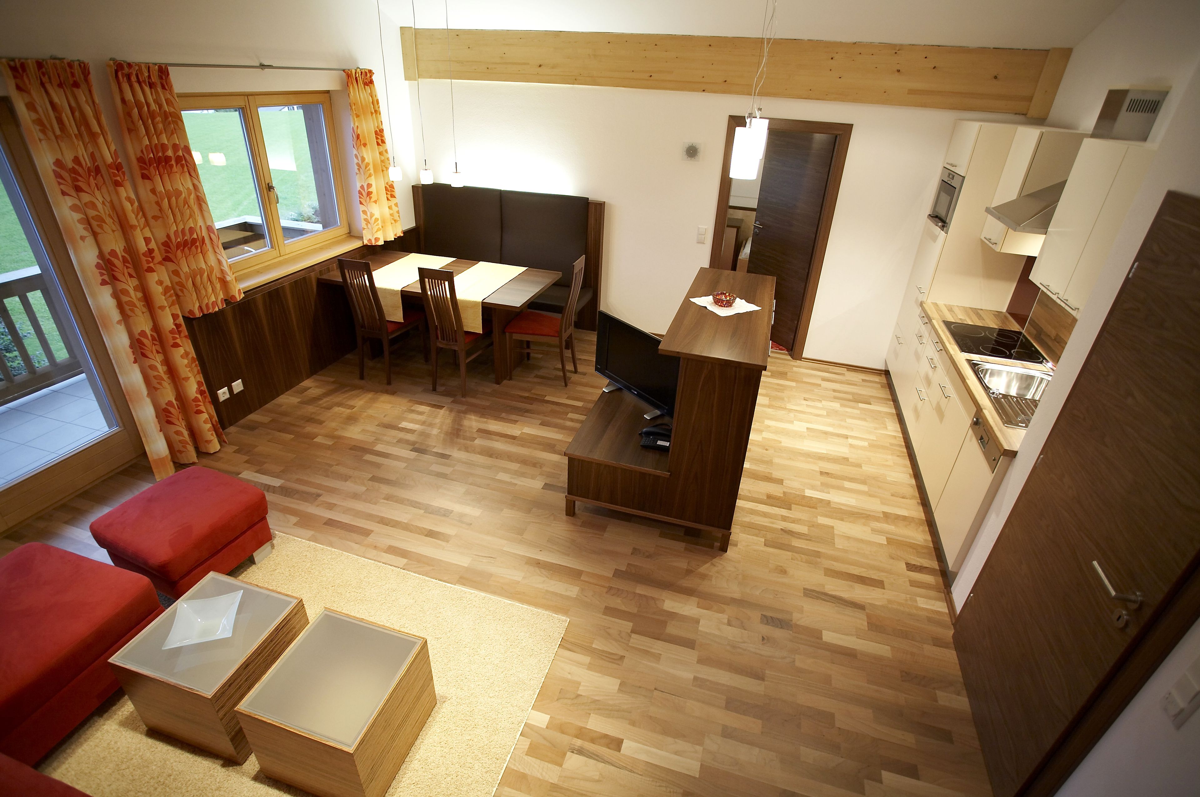 A compact living space with a dining area, a TV, and a kitchenette.