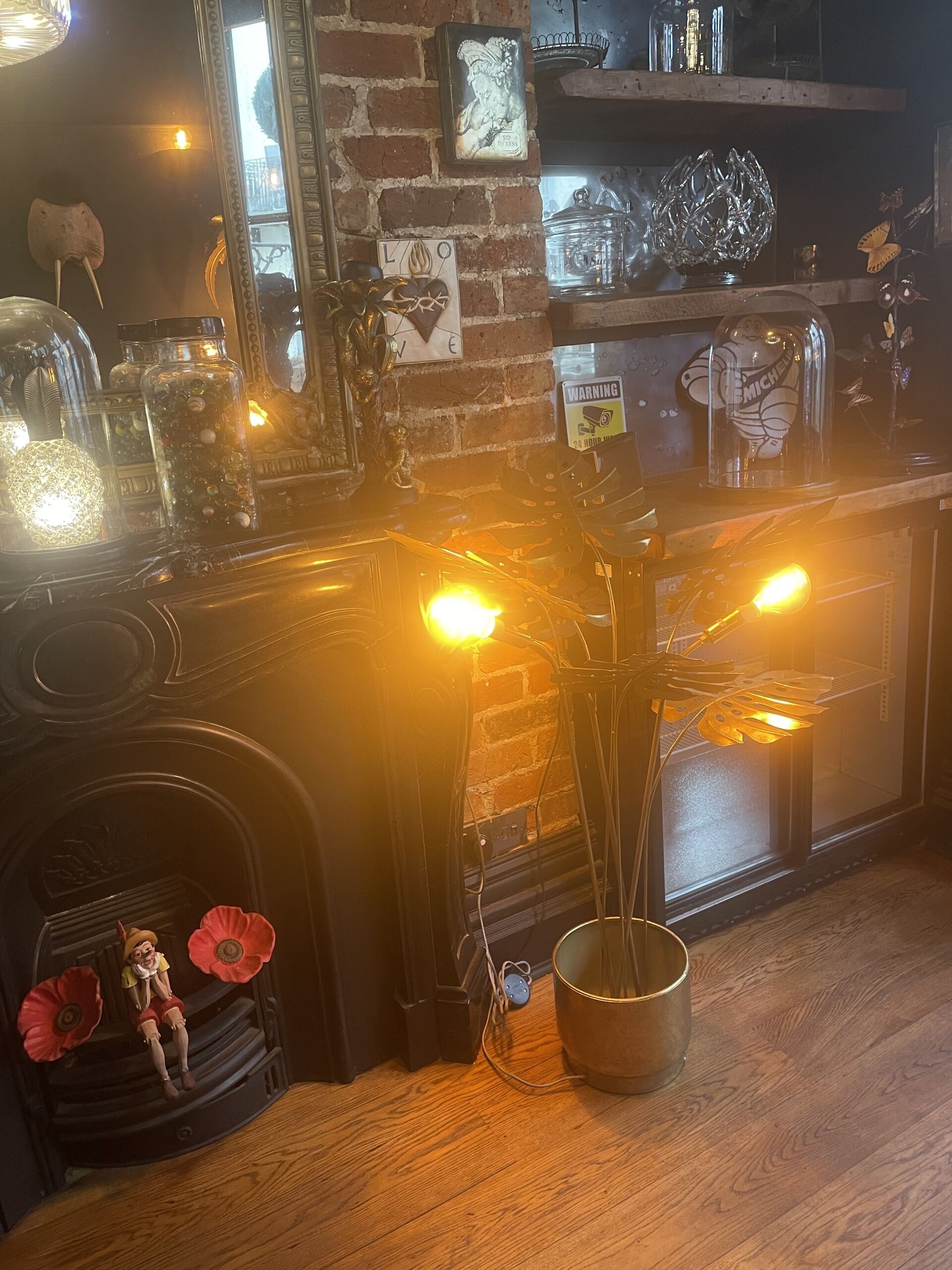 A cozy bar area with a brick wall, decorative jars, and a small statue.