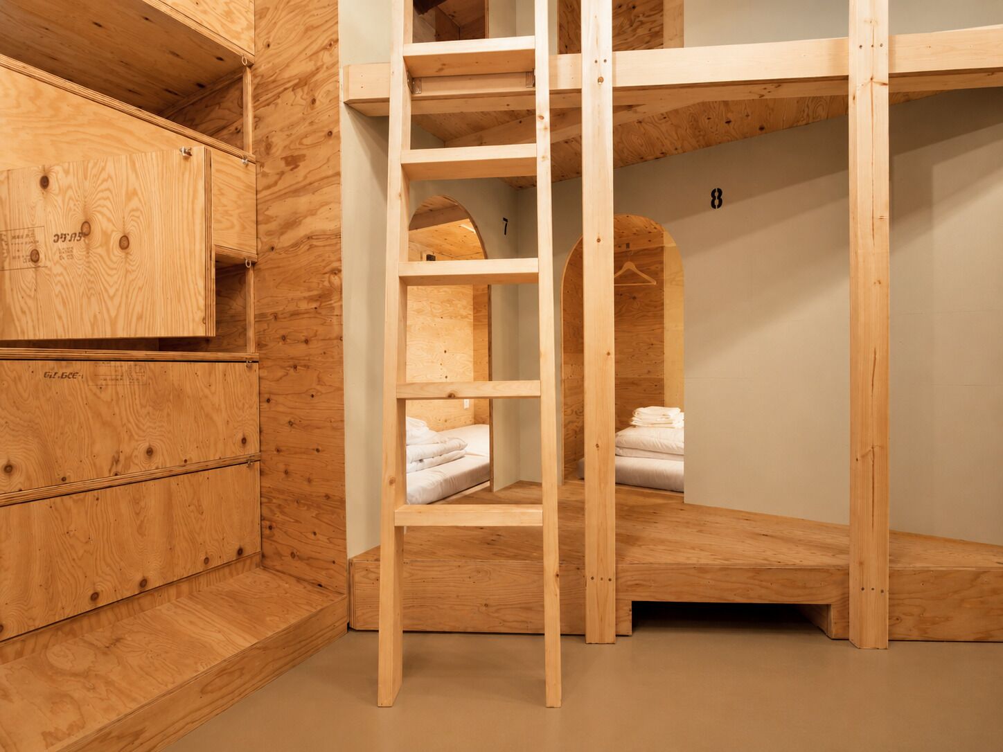 A bunk bed room with a wooden ladder, a small closet, and a number '8' on the wall.