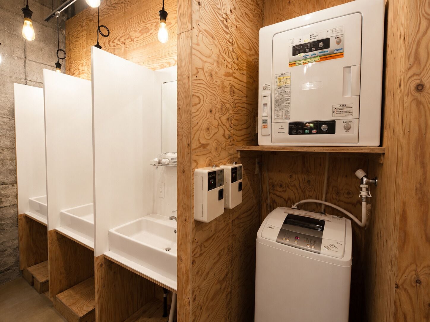 Eine Reihe von Holzbarkassen mit einem weißen Waschbecken, einem Warmwasserbereiter und einer Steuerung.