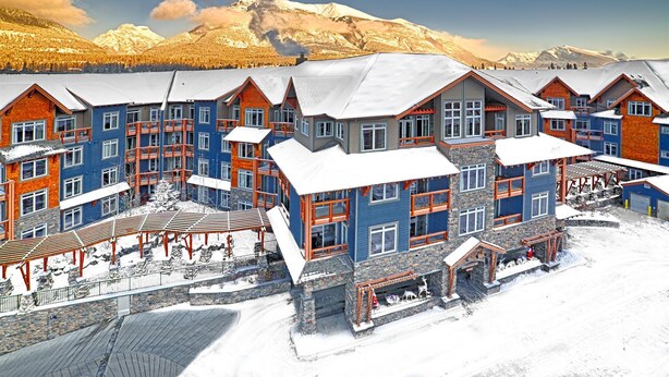 A multi-story lodge with a ski slope and mountain views. - Luxury Suites At The Blackstone Mountain Lodge 1 Bedroom Condo (Canmore)