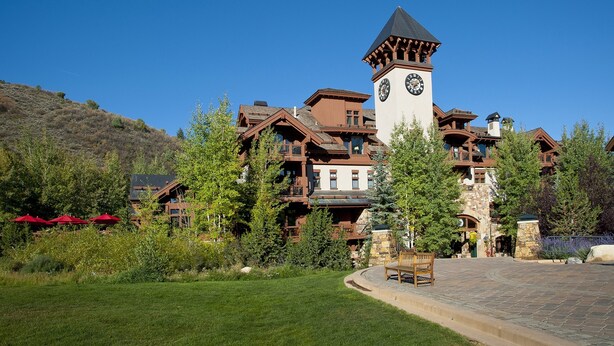 Un gran resort con una imponente torre de reloj, varios balcones y un césped bien cuidado.