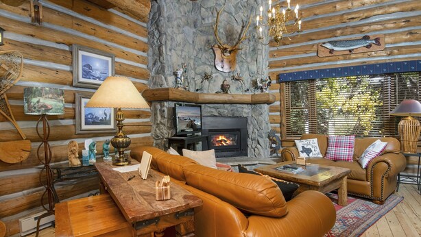 A cozy log cabin interior with a fireplace, leather furniture, and rustic decor. - Timbercreek #8b 2 Bedroom Home by RedAwning (Vail)
