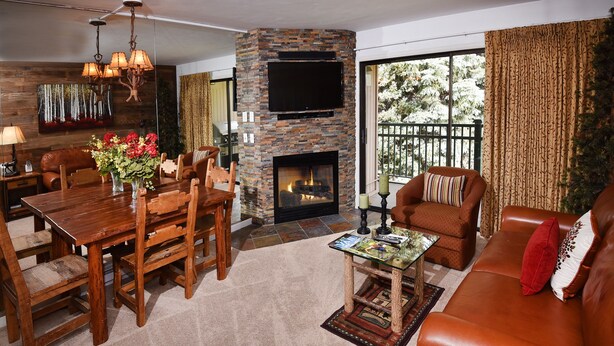 A cozy living room with a fireplace, a dining area, and a comfortable seating arrangement.