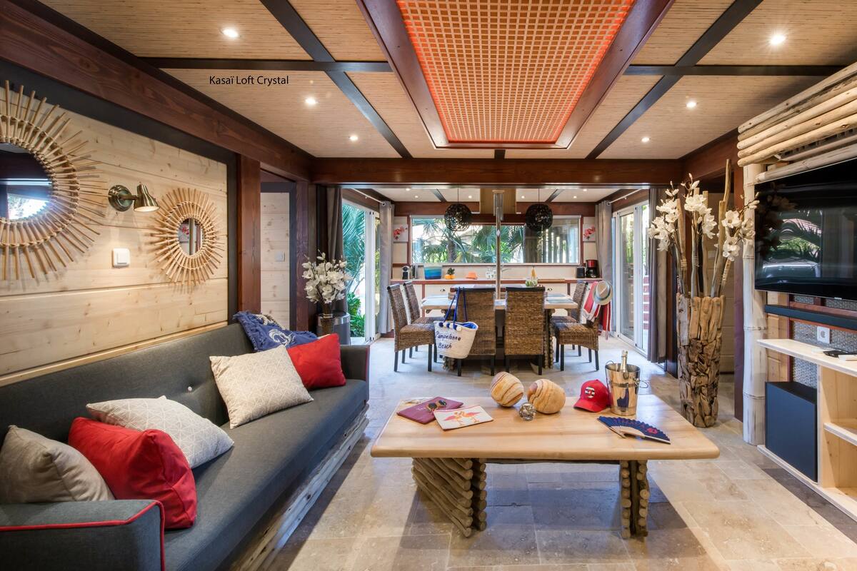 A cozy living area with a sofa, a wooden coffee table, and a TV on the right.