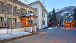A hotel with a balcony, a snow-covered ground, and a mountain in the background. - Riva Ridge 630 4 Bedroom Condo by RedAwning (Vail)