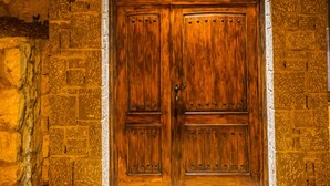 A wooden double door with a stone facade and an arched entrance. - Apartments Bazar (Ulcinj)