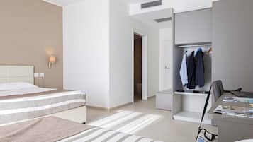 Une chambre d’hôtel comprenant un lit, un bureau, une chaise, une armoire et un placard.