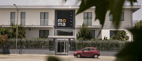 A modern building with a sign reading "mo ma hotel."