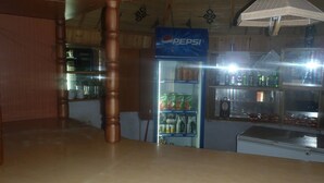 Quarto com teto de madeira, geladeira Pepsi abastecida com bebidas e janela com vista para o exterior.