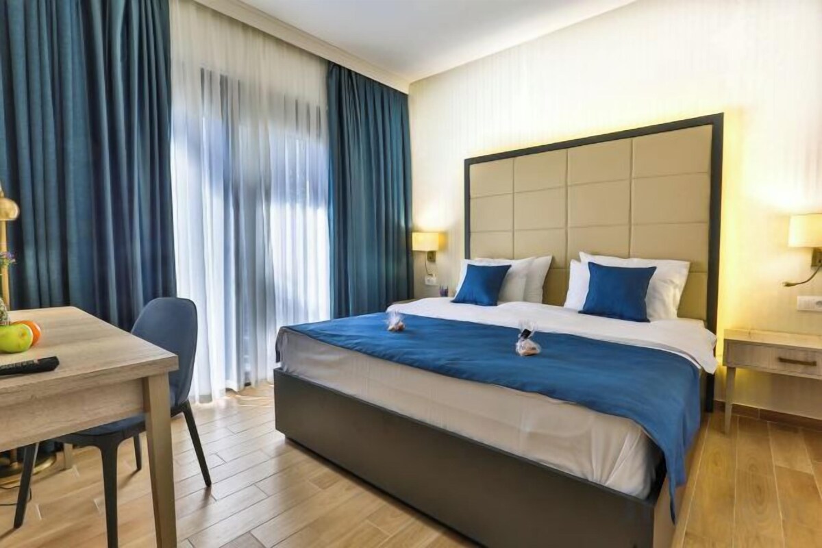 Habitación de hotel con una cama grande, un escritorio y una silla.