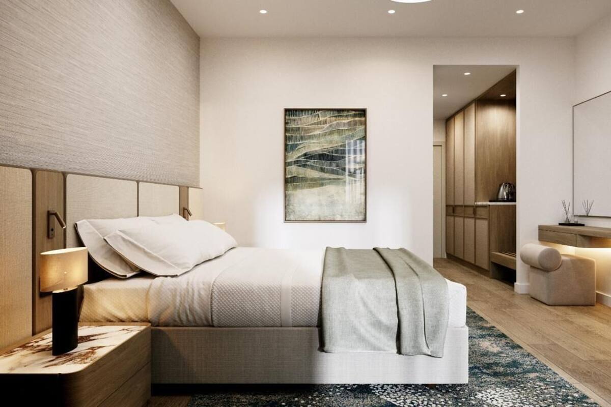 Een moderne slaapkamer met een bed, nachtkastje en een groot kunstwerk aan de muur.
