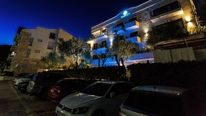 A multi-story hotel with a modern design, featuring balconies and a well-lit facade. - Hotel Harmony by Aycon (Petrovac)