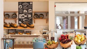 A bakery display with bread and pastries, a fruit bowl, and a wall with bakery-related illustrations.